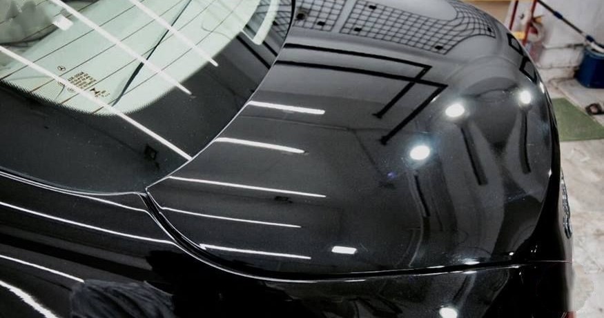 After paint correction — gloss black trunk with mirror finish